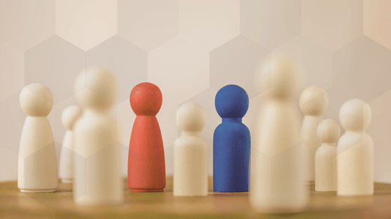 Familienaufstellung - Farbig sortierte Holzfiguren als Bild für Beziehungssysteme und Rollen