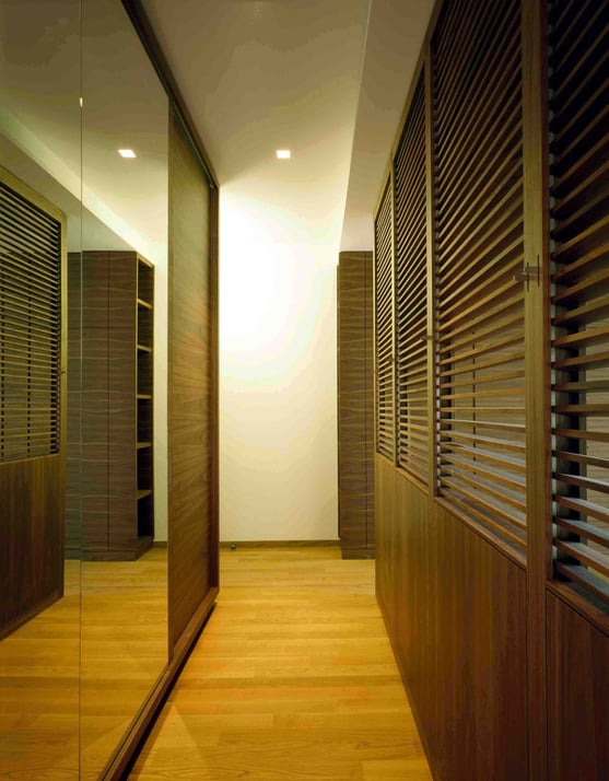 Schrankraum aus Holzwerkstoffplatten furniert und Nussholz massiv, Schiebetüren verspiegelt. Zum Schlafbereich mit verstellbaren Holzlamellen aus Nussholz abdunkelbar - Foto © G. Zugmann