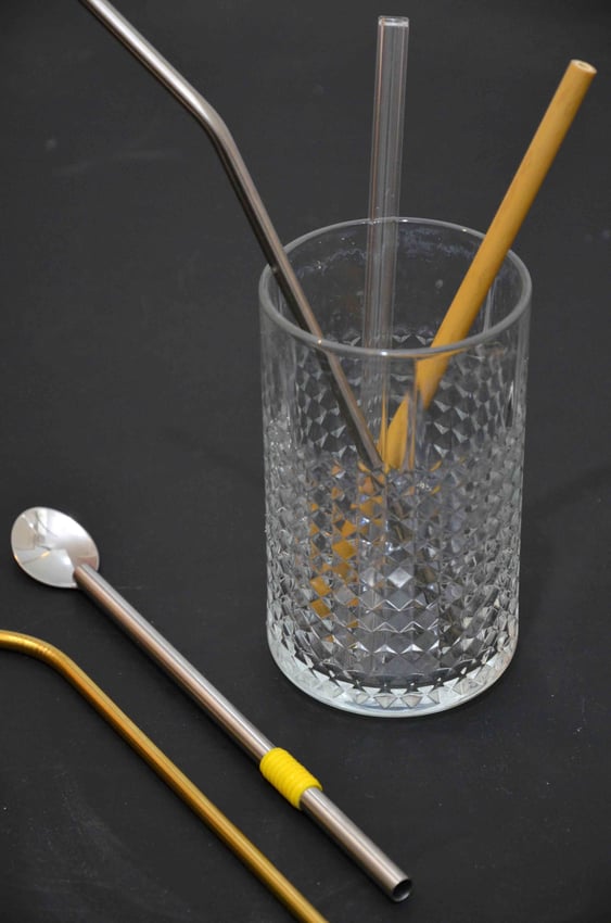 Trinkglas mit verschiedenen nachhaltigen Strohhalmen aus Glas, Edelstahl und Bambus