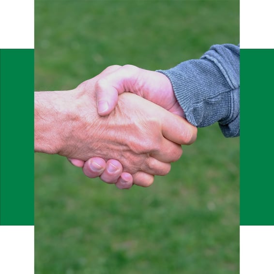 Zwei Personen geben sich die Hand und symbolisieren damit Vertrauen, Partnerschaft und eine erfolgreiche Zusammenarbeit.