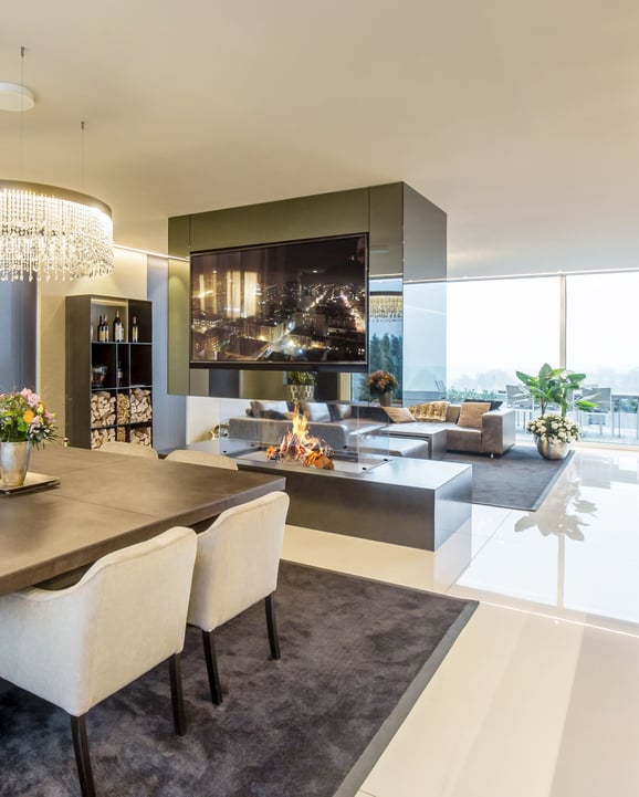 Insert de cheminée STAFFIERI: La cheminée sans cadre à quatre côtés, fabriquée à l'unité, crée un point central qui attire tous les regards dans le mélange de design moderne de l'aménagement intérieur.