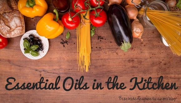 "Essential Oils in the Kitchen" over cutting board with fresh food