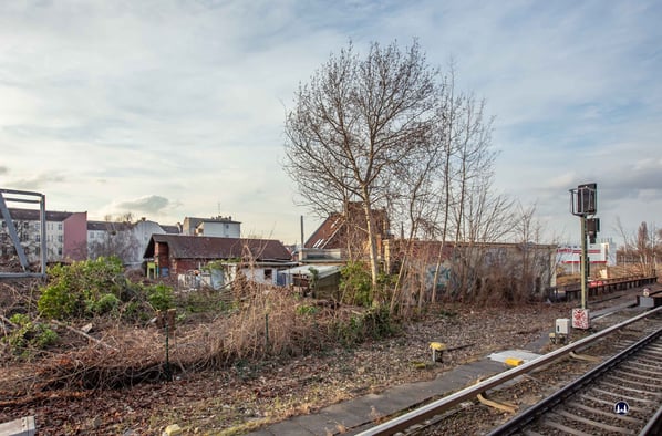 Blick vom Bahnsteig auf das Empfangsgebäude des S-Bahnhofs Yorckstraße (rechts, kurz vor dem Einfahrsignal), dem benachbarten Gaststättengebäude mit seinem hohen Dach und dem ehem. "Contorgebäude".