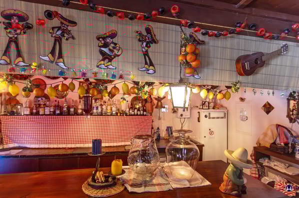 Die Theke der Cantina, liebevoll dekoriert mit allerlei Figuren, Musikinstrumenten und künstlichen Früchten.