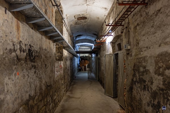 Von der Steintreppe geht es vorbei an zahlreichen, zum Teil durch Gittertüren abschließbare Nebengewölbe.