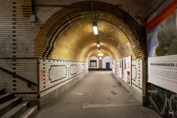 Der unter den Gleisen verlaufende Verbindungsgang von der Bahnsteighalle (hinten) zum Treppenzugang des Bahnsteigs (links). 