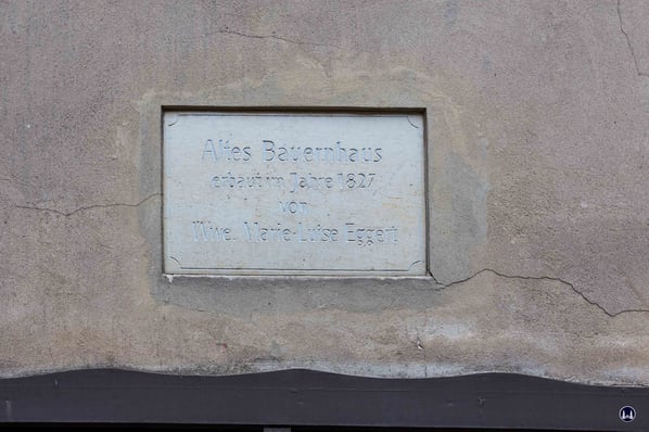 Die an die Witwe Marie-Louise Eggert erinnernde Gedenktafel über dem Tor des Gesindehauses im Hof der Neuköllner Karl-Marx-Straße 178.