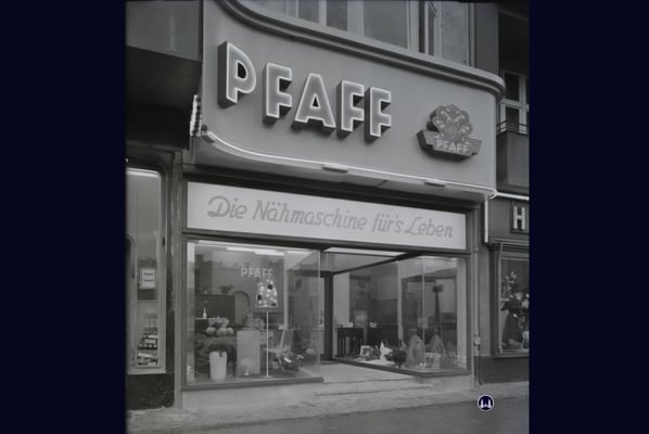 Das Nähmaschinengeschäft vermutlich im Eröffnungsjahr 1955. Neben der damaligen Leuchtreklame ist vor allem der erheblich nach hinten versetzte Ladeneingang auffällig.