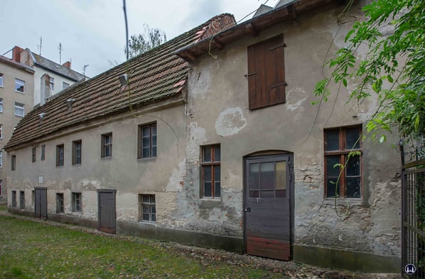 Zwischen 1890 und 1904 wird das Gesindehaus um eine Remise (erkennbar an dem doppelflügeligen Tor direkt unter der Gedenktafel sowie den kleineren Fenstern an der Traufkante des Daches) und einem Holzschuppen ergänzt.