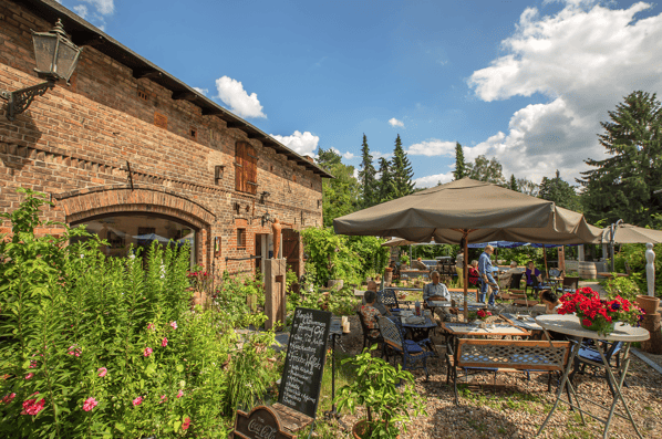 Café im Auenhof und die Kunstgalerie Aagaard im Berliner Stadtteil Hermsdorf. Gemütliche Sitzplätze locken im Garten.
