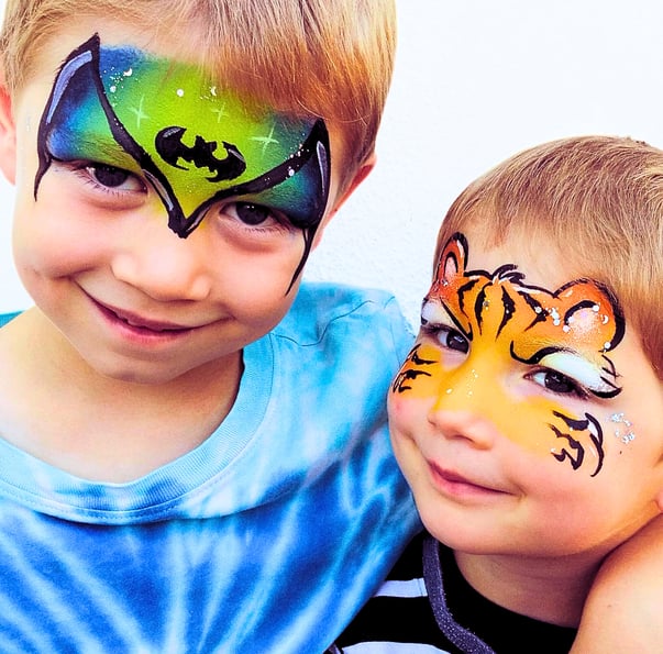zwei als Fledermaus und Tiger geschminkte Jungs 
