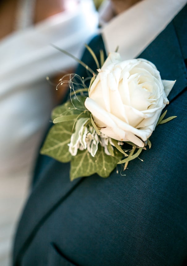 Eine helle Blume am Jackett des Bräutigams