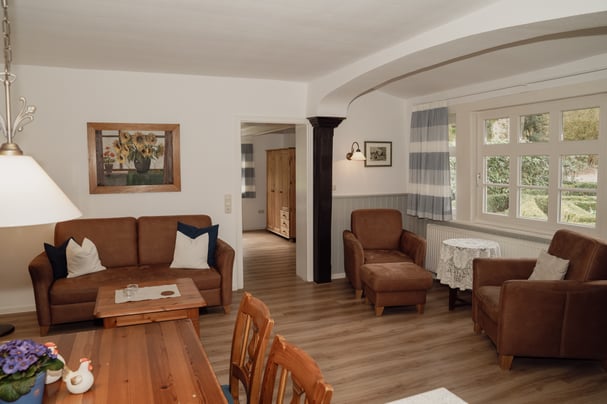 Wohnzimmer in Wohnung 1A, Blick auf das Sofa und den Essbereich