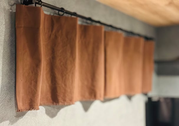 小窓に取り付けられた帆布カーテン。やさしいブラウンカラーが空間を包み込む