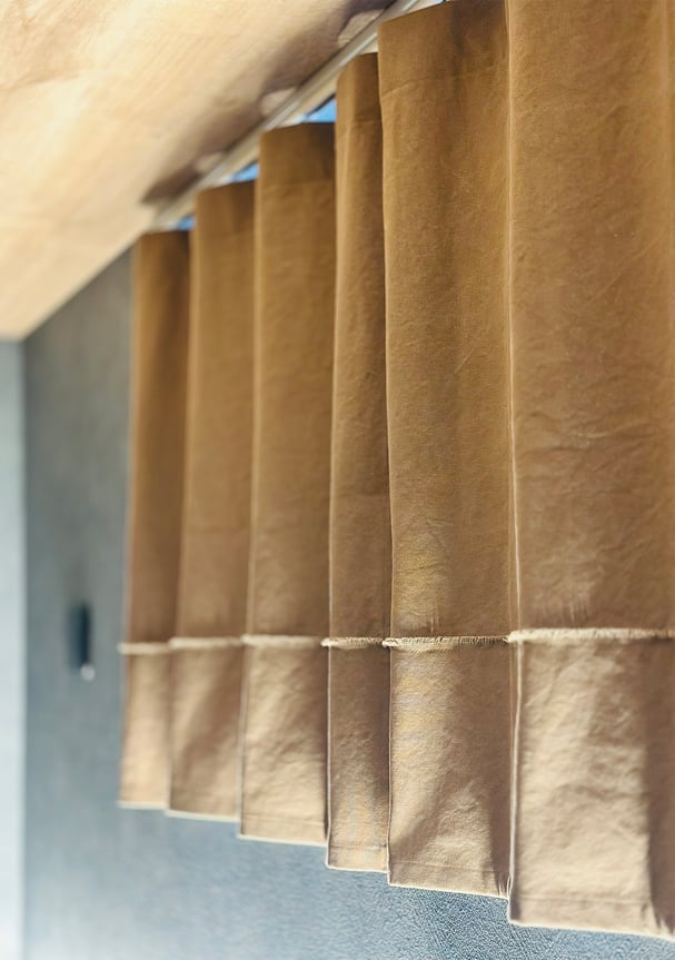 帆布カーテン越しに光が差し込む様子。生地の質感が際立ち、柔らかな陰影をつくる