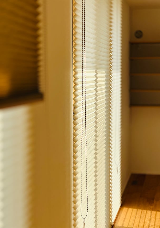 カーテンボックスにすっきり納まったプリーツスクリーン。チェーン操作でスムーズに開閉できる。