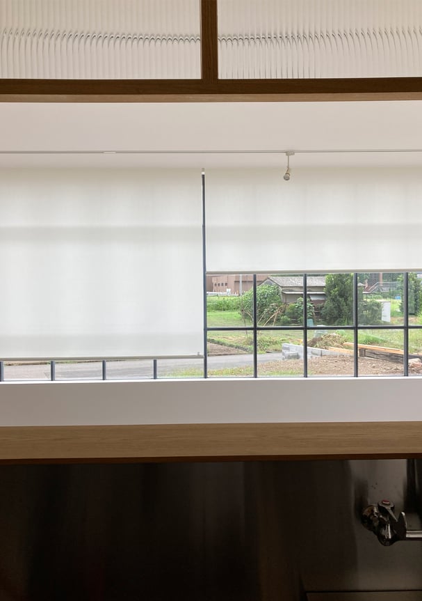 防炎仕様のロールスクリーン。柔らかな光を通し、外の景色をやさしく映す