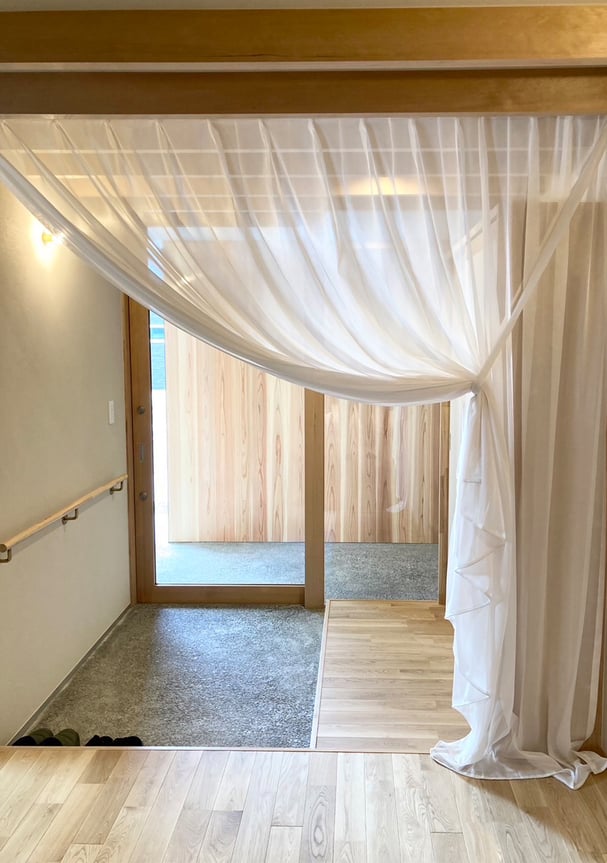 カーテンBOXに収められた間仕切りカーテン。アーチ状にドレープがかかり、LDKへ誘うような柔らかいラインを描く