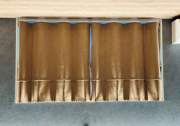 天井付けで設置された帆布カーテン。縦のラインが強調され、天井が高く見える効果