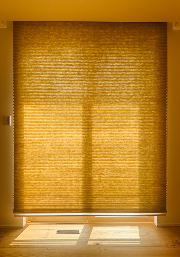 プリーツスクリーンを全閉にした状態。厚地生地が光をやわらかく遮り、温かみのある雰囲気に。