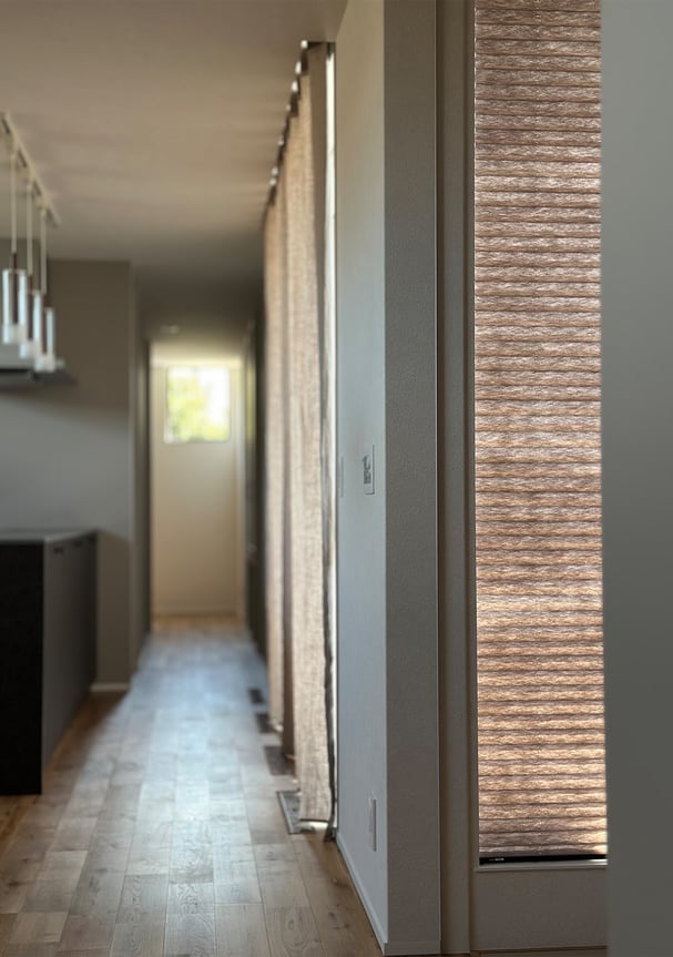 シングルプリーツのスクリーン。やわらかなブラウンカラーが光を通し落ち着いた印象を与える