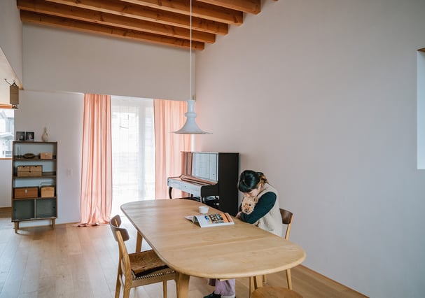 桜染のカーテンが光を透かすリビングの様子