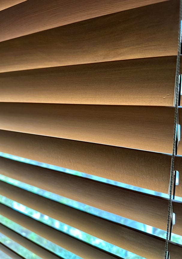 ウッドブラインドのスラットをクローズアップ。柔らかな光が木目を照らしている