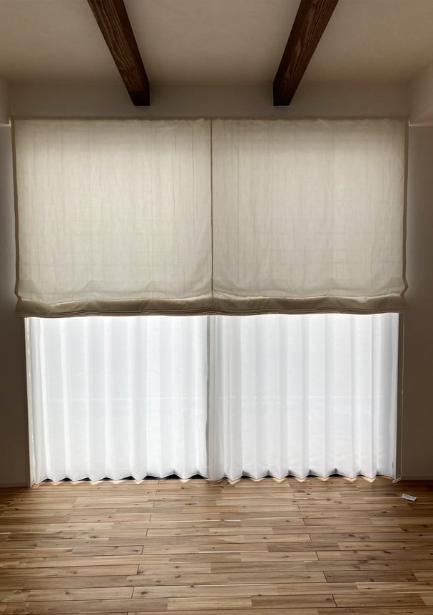 昇降式のドレープを半分まで下げた状態。レースは開けられるため、採光や換気にも柔軟に対応できる。