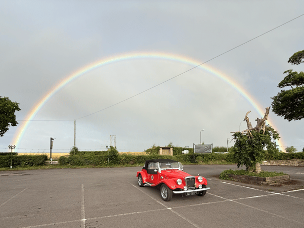 Photo of car with a rainbow
