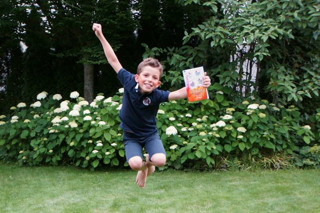 Joel Meyer mit seinem Buch "Auf der Suche nach den verschwundenen Hühnchen" im Garten