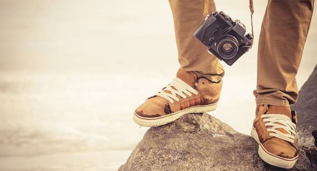 Füße eines Mannes, der auf einen Felsen steht, und Kamera