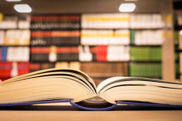 Offenes Buch vor Bücherregal