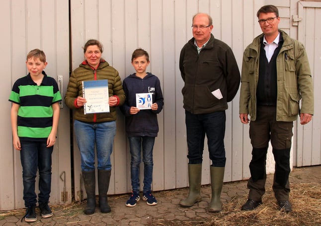 Gruppenfoto mit Urkunde und Plakette in der Hand