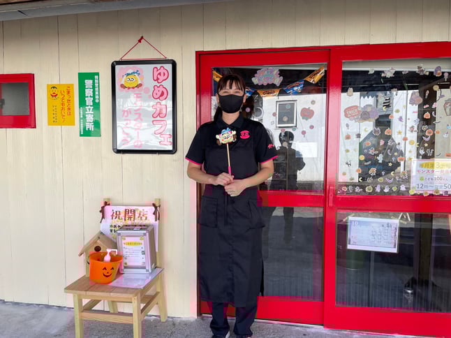 店長の古藤裕理笑さんと活動の拠点となる新店舗「ゆめカフェ・モンスターの学校」の写真