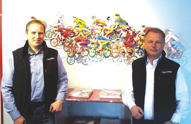 Wilhelm Humpert IV (rechts) und Prokurist Jens Stahlschmidt vor dem Fahrradgemälde im Eingang.