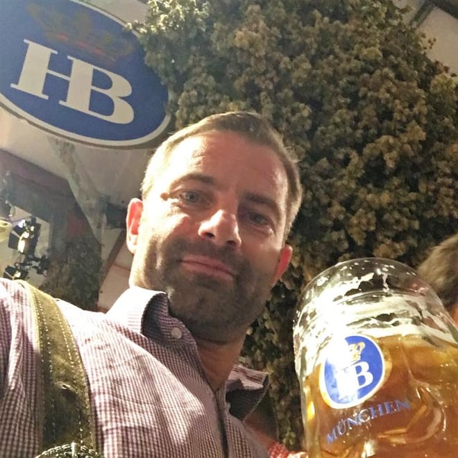 freaky finance, Oktoberfest, Wiesn, Hofbräuzelt, Mann mit Bierkrug, Hopfen im Hintergrund