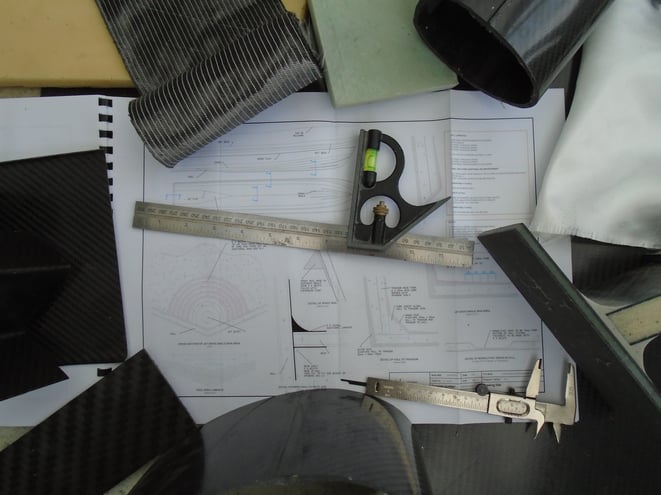 Carbon fibre, fiberglass, SAN core composite materials, technical construction drawings and accurate measuring tools.