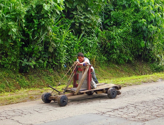 Gesteuert wird mit den Füssen direkt auf die Vorderachse. Zum Bremsen zieht der Fahrer am Hebel und drückt Bremsbacken auf die Hinterräder. Genial einfach.