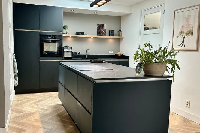 Binnenkijker - donkere zwart matte keuken met planken