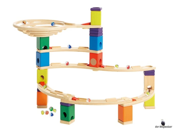 Im Paket Hape sind 19 Holzquader, 5 Kurvenschienen, ein Trichter, 10 Distanzscheiben, 7 Grundplatten, 4 Lochschliesser, 9 Beschleuniger, eine S-Schiene und 50 bunte Glasmurmeln enthalten.