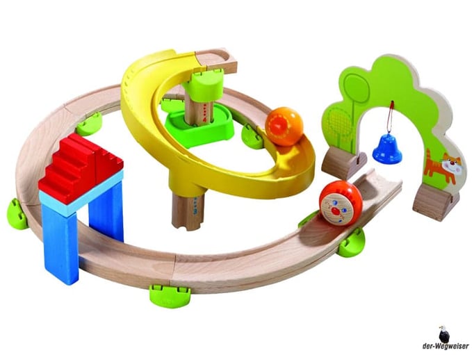 Im Paket Hape sind 26 Einzelteile, ein Glöckchen-Tor, eine Kugel-Steilkurve, fünf Kurven, eine Gerade, acht Verbindungselemente, ein Startstein, zwei Säulen, drei Dominosteine, zwei Treppensteine, eine Kugel Paul, eine Kugel enthalten.