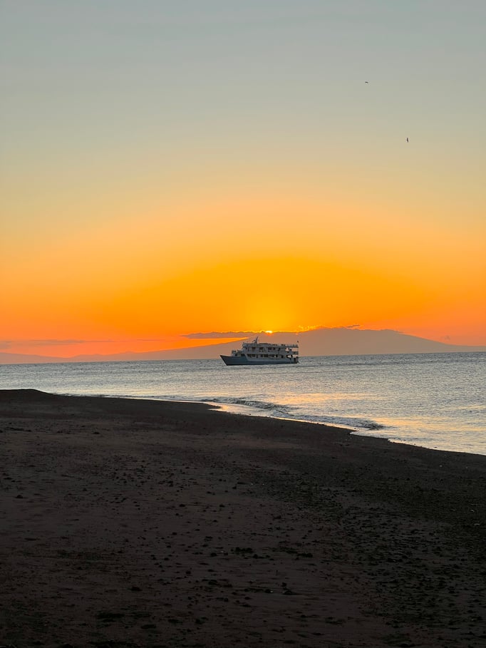 A photo of an orange sunset with the Aqua in the distance