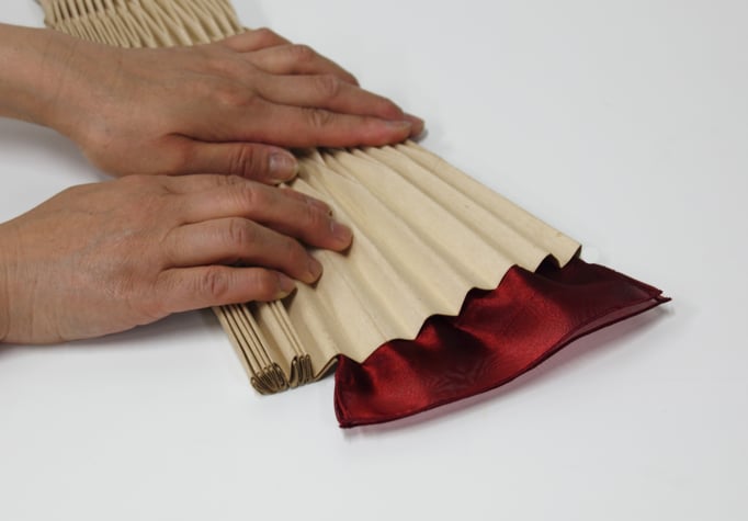 ②ハンドプリーツ　専用型紙に生地を挟み、真空釜加工すると・・・