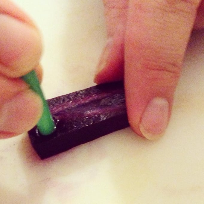 Mit einem Strohhalm lassen sich hervorragend runde Löcher in buntes Gemüse (hier: Möhren) stanzen.