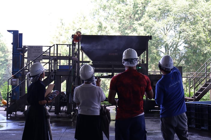 液体飼料の写真を撮影する生徒たち