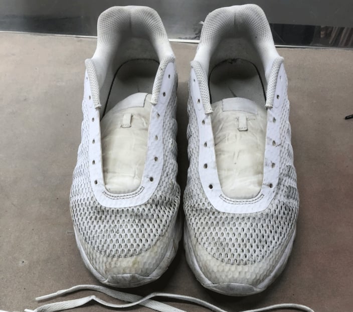 白のスニーカーが汚れている画像。黒い汚れが付いている。