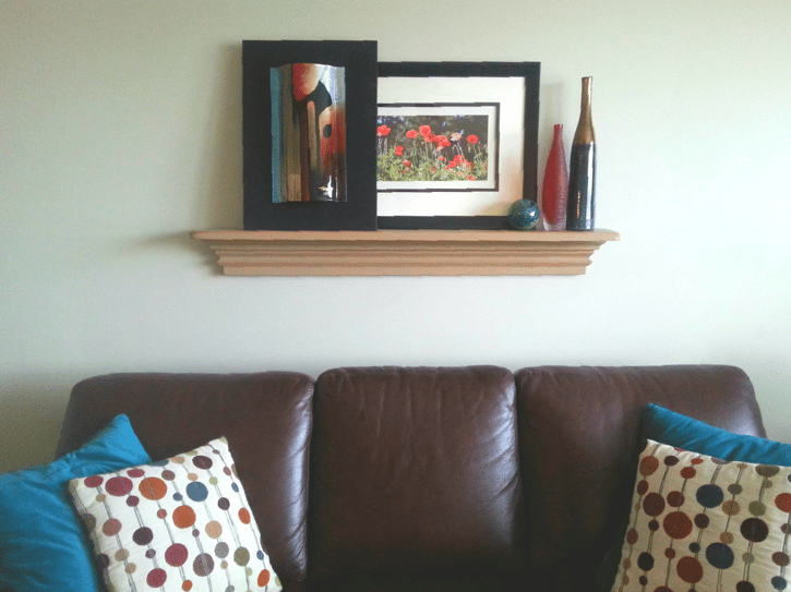 A painted picture shelf styled like a mantle gives the right proportions over the sofa and allows for changing the art and accessories.