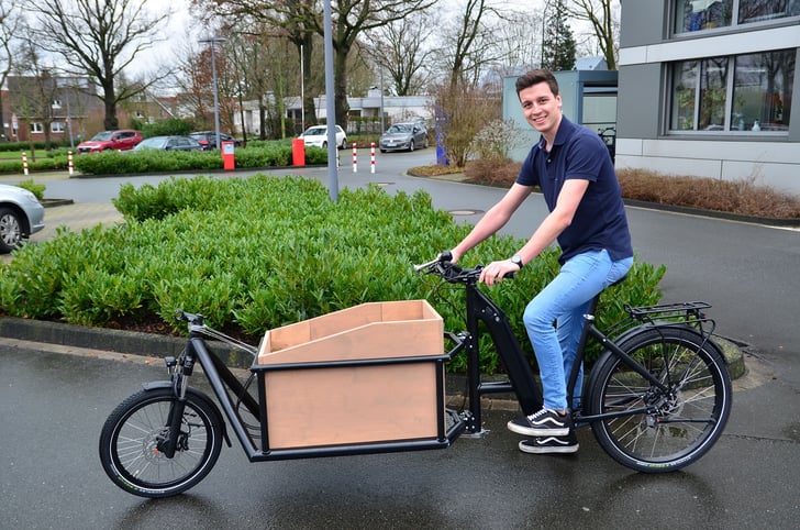 Studierende am Fachbereich Maschinenbau konstruieren Lastenfahrräder in Zusammenarbeit mit dem Unternehmen Velo de Ville. Bild: Jannis Kuschel bei der Testfahrt mit dem ersten fertigen Fahrrad im Frühjahr 2022. (Foto: FH Münster/Frederik Tebbe