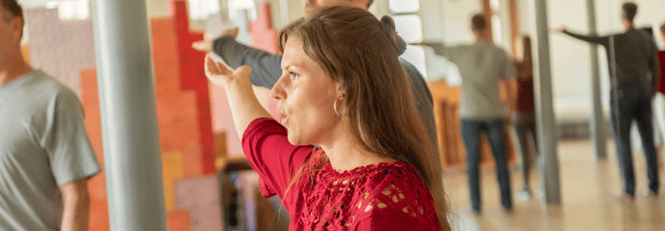 „Sängerin in rotem Oberteil beim praktischen Gesangsunterricht während der Ausbildung im Potential Oriented Vocal Training – effektiv Singen mit körperlicher Ausrichtung in der Gesangspädagogik