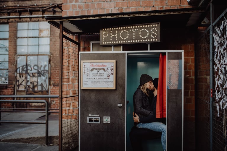 Verliebtes Jahr küsst sich in einer Fotokabine in Berlin fotografiert von Portraitfotografin Uschi Kitschke aus Kreuzau.